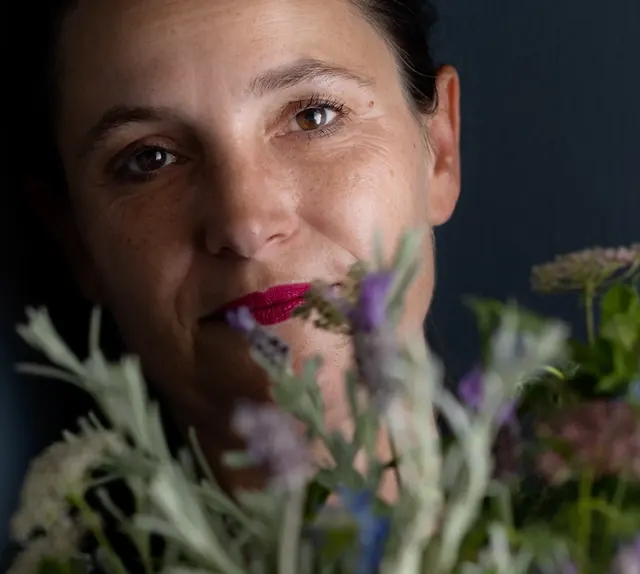 Portrait of Buunch founder Caroline Bailly photographed among seasonal flowers in the studio.