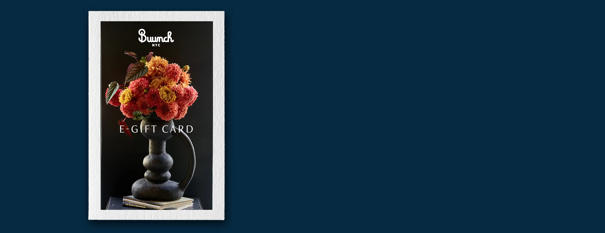 The Buunch e-gift card: a red arrangement in a dark vase on a stack of books