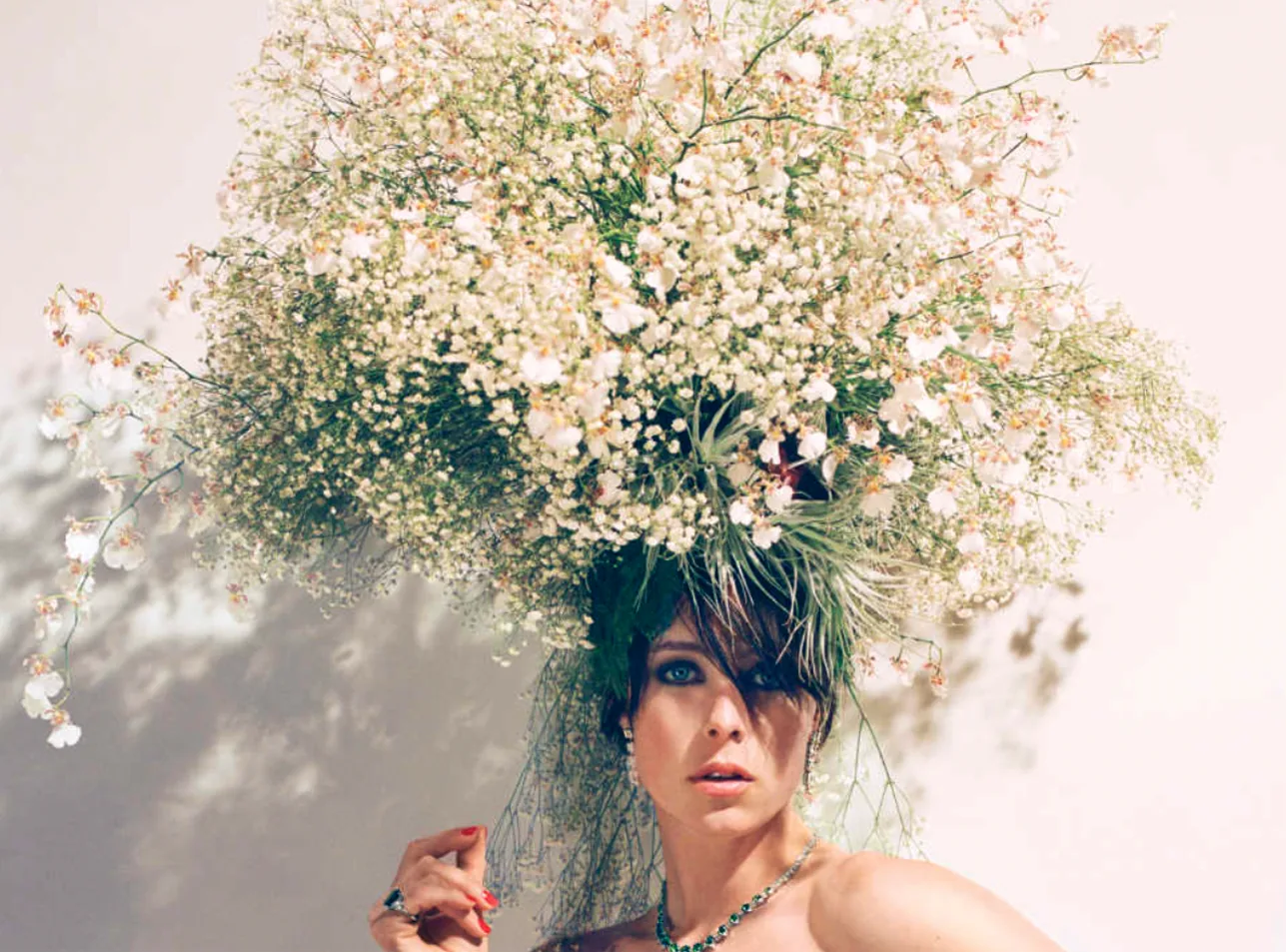 A model beneath a suspended canopy of white flowering branches