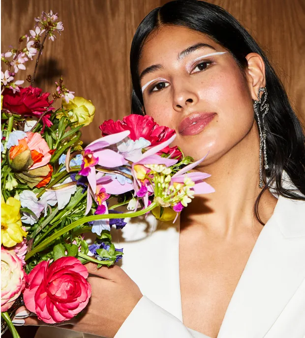 A bride-to-be holding a bouquet of garden roses and sweet peas