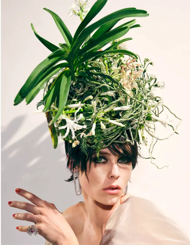 A model beneath a headdress of orchids and trailing greenery