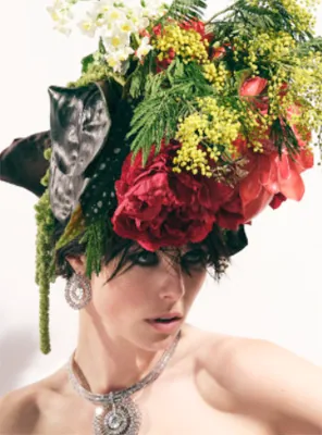 A model with a red and green floral headdress