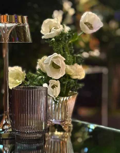 White anemones arranged in small metallic vases.